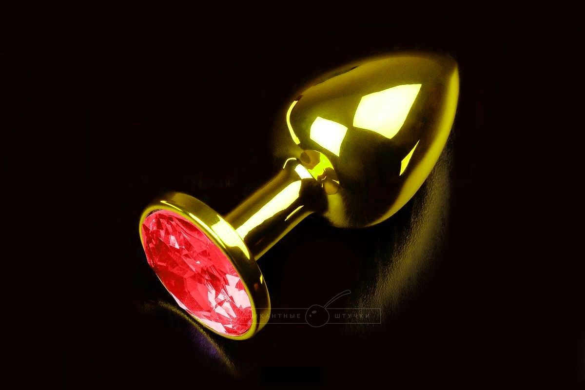 Купить Маленькая золотистая анальная пробка с круглым кончиком и красным кристаллом - 7 см. в Москве.